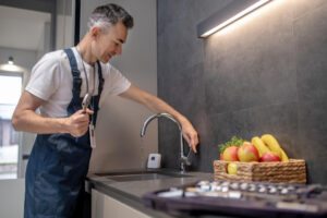 A plumber fixing a kitchen faucet